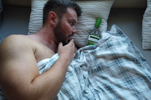 Andy erschreckt neben einer Flasche Wodka im Bett