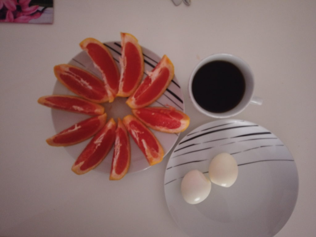 Grapefruit mit Eiern und Kaffee